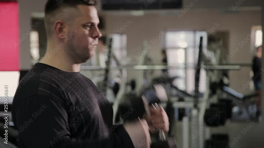 Fat man training with dumbbells in the gym. Fat man training with dumbbells in the gym.