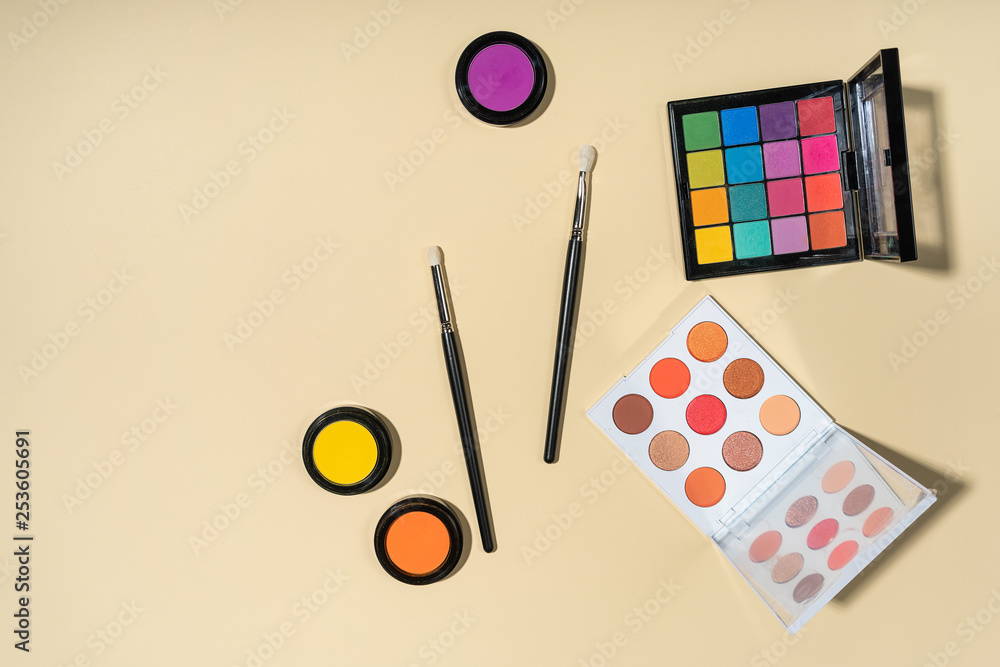 Set of brushes and eyeshadows on a yellow background Set of brushes and eyeshadows on a yellow background
