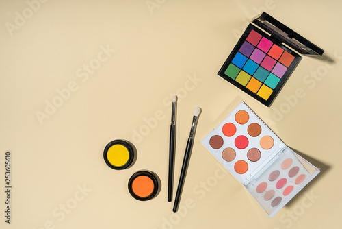 Set of brushes and eyeshadows on a yellow background