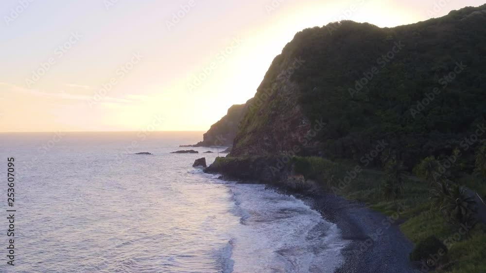 Aerial view of the Hawaiian island Maui and its jungle covered cliff landscape, in the setting sun. Aerial view of the Hawaiian island Maui and its jungle covered cliff landscape, in the setting sun.