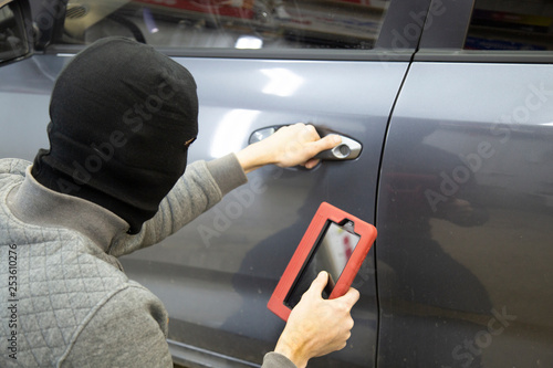 Fotografie The hijacker tries to break into the car with a scanner