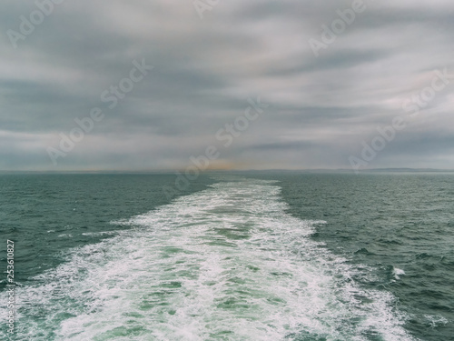 View from the back of a ferry crossing the English Channel, UK, Europe. Industrial/urban pollution from Portsmouth in the distance.