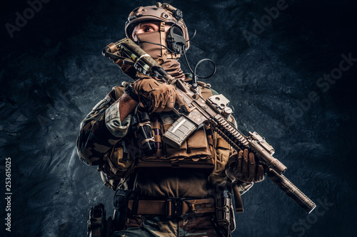 Fotografie Elite unit, special forces soldier in camouflage uniform posing with assault rifle