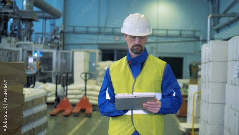 Male expert with a tablet computer is walking along the plant facility Male expert with a tablet computer is walking along the plant facility
