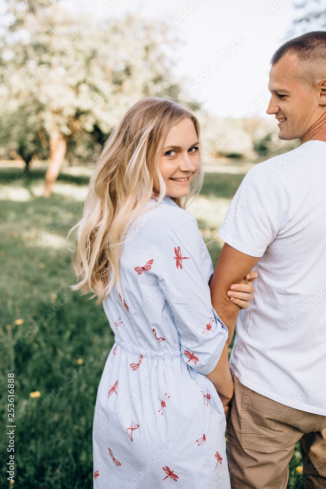 Happy young couple in love hugging enjoys spring day, loving carefree together outdoors walking at park Happy young couple in love hugging enjoys spring day, loving carefree together outdoors walking at park