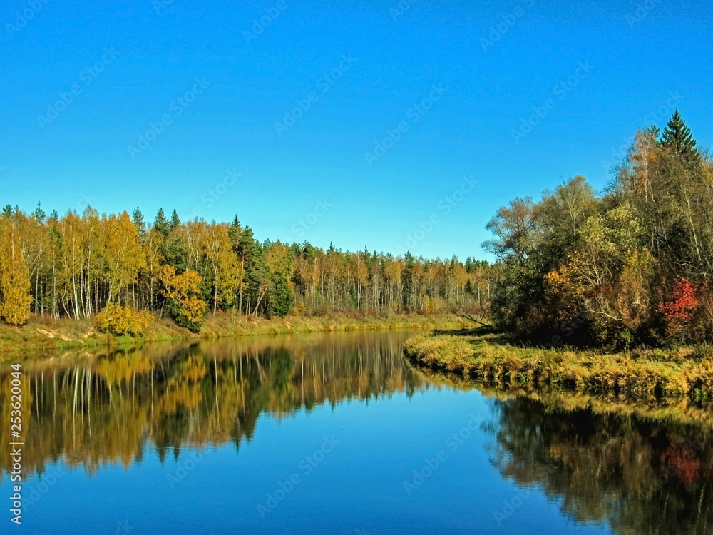 Autumn landscape of Gauja river valley and colorful forest reflecting in mirror water Autumn landscape of Gauja river valley and colorful forest reflecting in mirror water