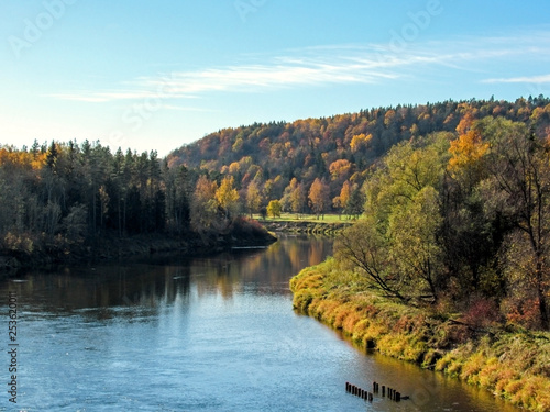 Autumn landscape of Gauja river valley and colorful forest reflecting in mirror water photo