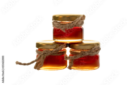 Pyramid of three small jars with honey decorated with jute string isolated on white background, idea for wedding gift