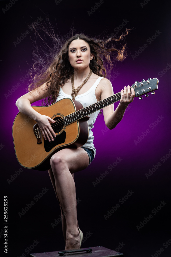 Young woman with guitar, isolated on black and violet background. Young woman with guitar, isolated on black and violet background.