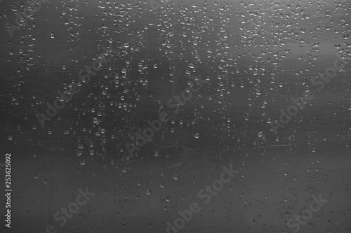 Water droplets on scratched metal, aluminium surface after rain