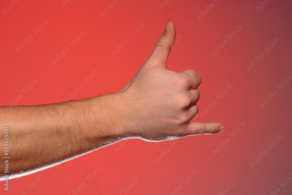 The sign of a phone call shows one-handed isolated on a red background