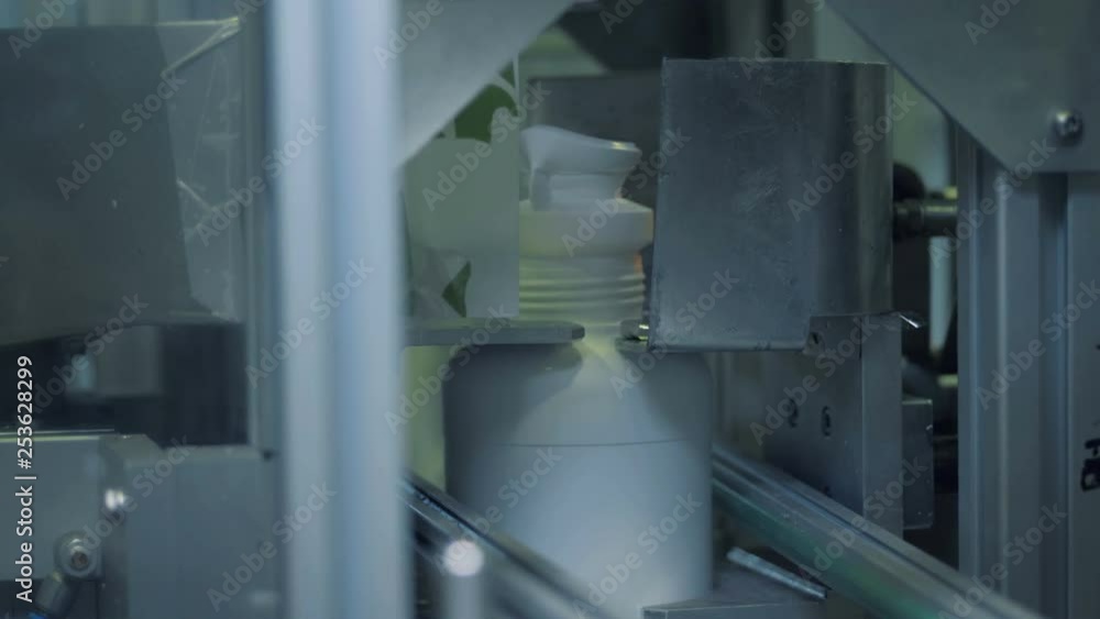 Close up of plastic bottles' necks getting chopped off mechanically Close up of plastic bottles' necks getting chopped off mechanically