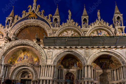 Italy, Venice, St Mark's Basilica at night, a church with a clock on the front of St Mark's Basilica © SkandaRamana