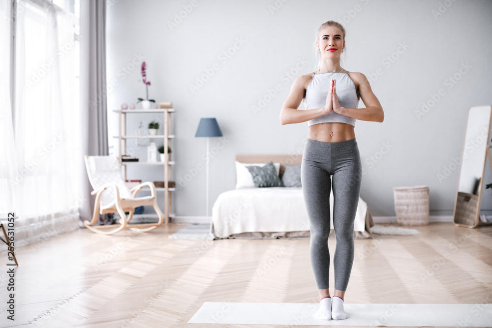 Young woman doing yoga at home, tree pose. Young woman doing yoga at home, tree pose.