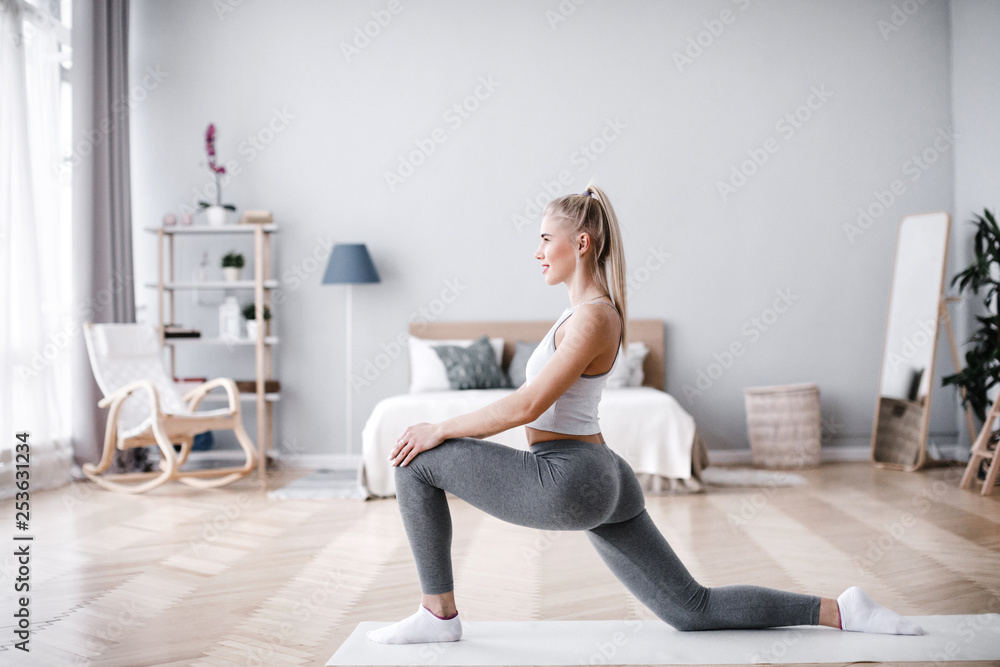 © BestForYou - Young sporty woman doing morning exercise in living room. © BestForYou - Young sporty woman doing morning exercise in living room.