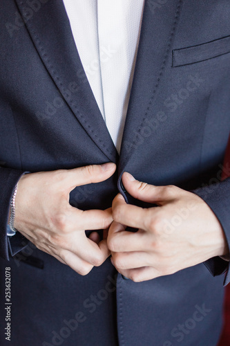 the man zips up his jacket, groom in a jacket, white tie, bridegroom's fees, business style.