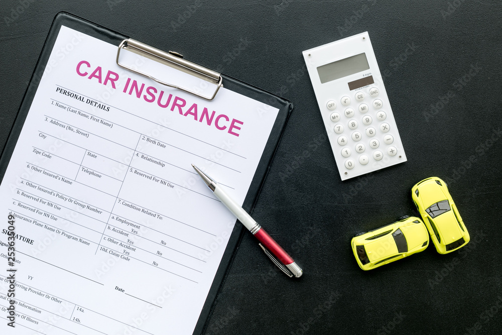 Car insurance form near toy, calculator, pen on black background top view Car insurance form near toy, calculator, pen on black background top view