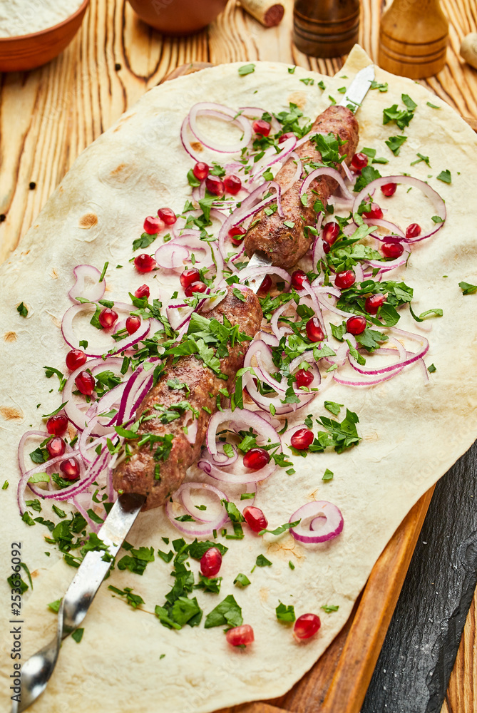 Lula kebab, Georgian dish with meat served by onions and greens in pita bread Lula kebab, Georgian dish with meat served by onions and greens in pita bread
