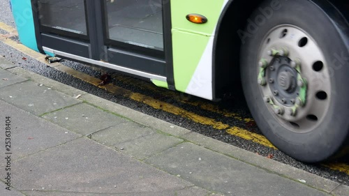 A very modern bus starts from the bus stop, closeup, Liverpool