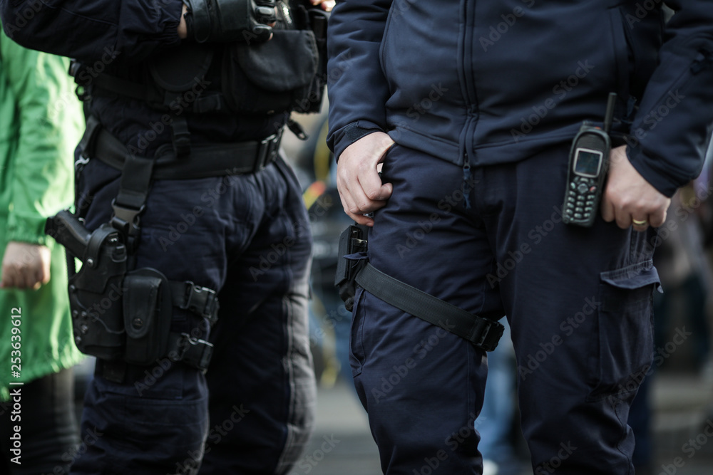 Details of the security kit of a riot police officer, including handcuffs, 9mm handgun, radio station and baton Details of the security kit of a riot police officer, including handcuffs, 9mm handgun, radio station and baton