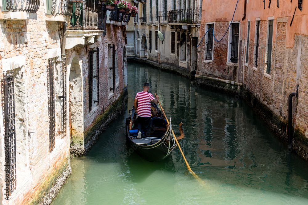 Italy, Venice, Gondolier navigating a gondola near San Moise on a canal
