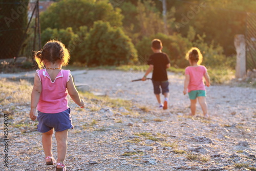Kids running on a stony ground in the sunset
