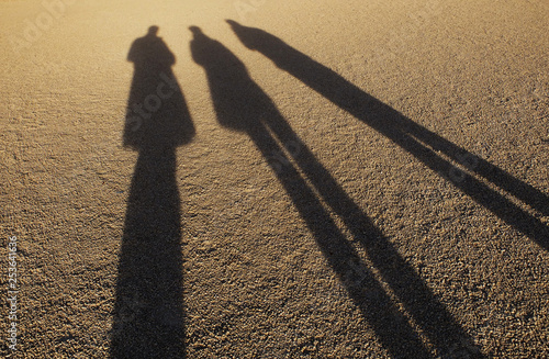 Silhouettes of three persons on the ground
