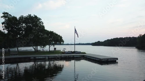 Aerial, American flag waves over lake in Milford, Michigan photo