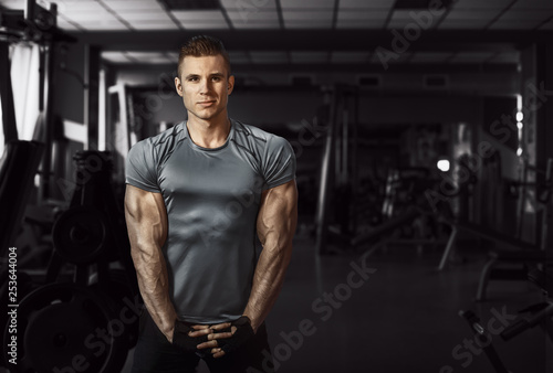 Muscular model sports young man exercising in gym. Portrait of sporty healthy strong muscle. Fitness trainer. Sport workout bodybuilding motivation concept. Sexy torso.