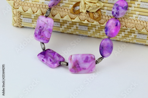 Beads made from natural stone sugilite,on a light background. photo