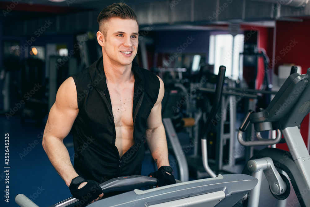 Muscular model young man exercising in gym. Portrait of sporty strong muscle. Fitness trainer. Sport workout bodybuilding motivation concept. Sexy naked torso, six pack abs. Male flexing his muscles. Muscular model young man exercising in gym. Portrait of sporty strong muscle. Fitness trainer. Sport workout bodybuilding motivation concept. Sexy naked torso, six pack abs. Male flexing his muscles.