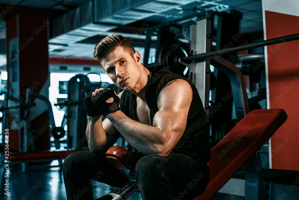 Muscular model young man exercising in gym. Portrait of sporty strong muscle. Fitness trainer. Sport workout bodybuilding motivation concept. Sexy naked torso, six pack abs. Male flexing his muscles. Muscular model young man exercising in gym. Portrait of sporty strong muscle. Fitness trainer. Sport workout bodybuilding motivation concept. Sexy naked torso, six pack abs. Male flexing his muscles.