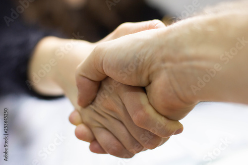 Two hands handshaking signing an agreement