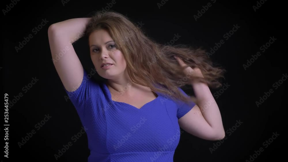 Closeup shoot of adult caucasian female with brunette hair posing seductively while looking at camera Closeup shoot of adult caucasian female with brunette hair posing seductively while looking at camera