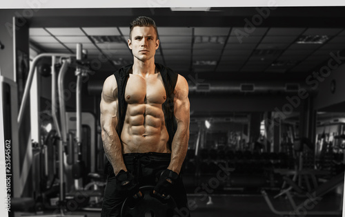 Muscular model sports young man exercising in gym. Portrait of sporty healthy strong muscle. Fitness trainer. Sport workout bodybuilding motivation concept. Sexy torso.