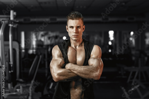 Muscular model sports young man exercising in gym. Portrait of sporty healthy strong muscle. Fitness trainer. Sport workout bodybuilding motivation concept. Sexy torso. © KDdesignphoto