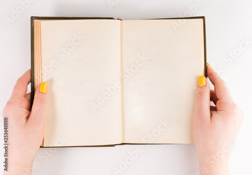 Hands holding opened book. Blank paper Mock-up