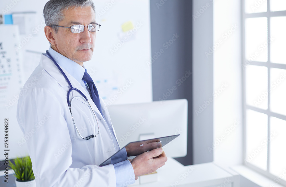 Male doctor writes notes on the clipboard in the hospital Male doctor writes notes on the clipboard in the hospital