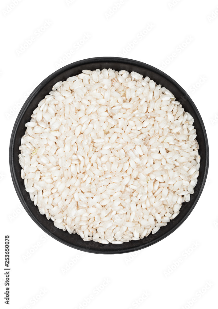 Black bowl of raw organic arborio risotto rice on white background. Healthy food. Black bowl of raw organic arborio risotto rice on white background. Healthy food.