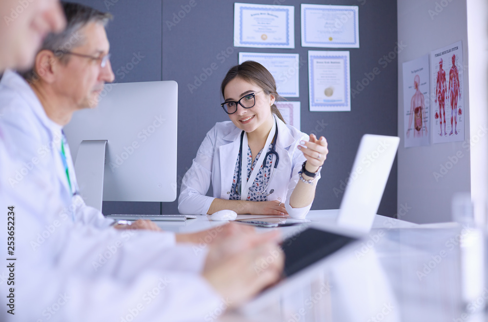 Serious medical team using a laptop in a bright office Serious medical team using a laptop in a bright office