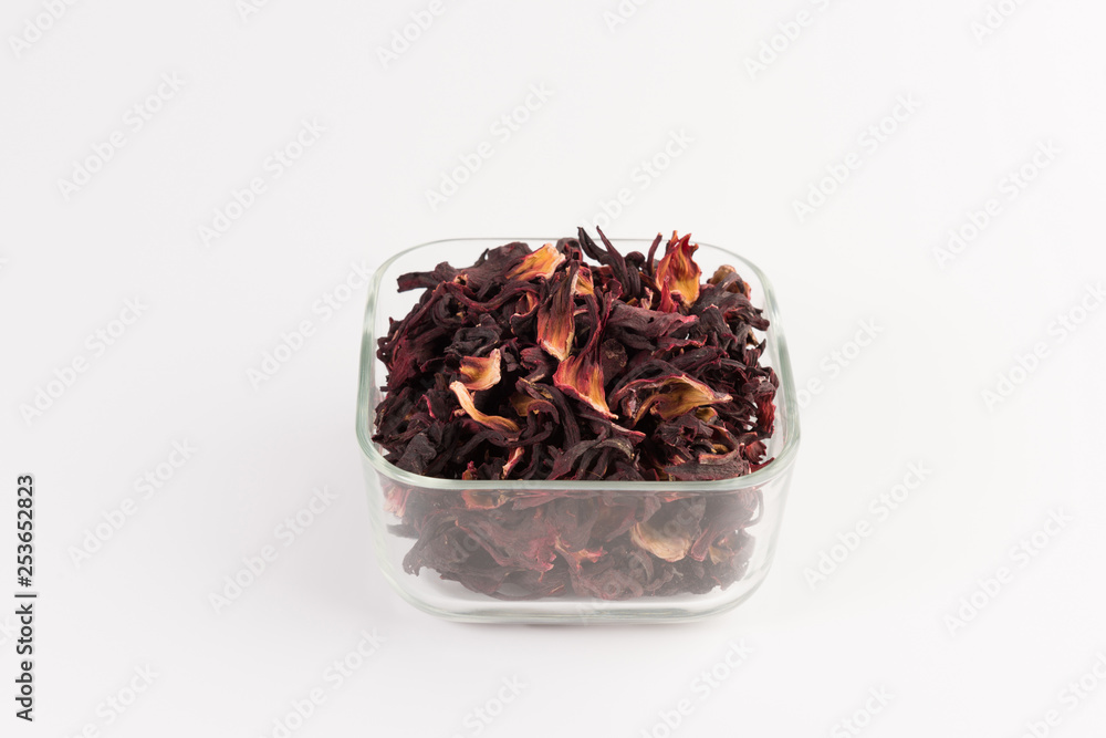 petals of dry hibiscus tea in the transparent bowl isolated on white background petals of dry hibiscus tea in the transparent bowl isolated on white background