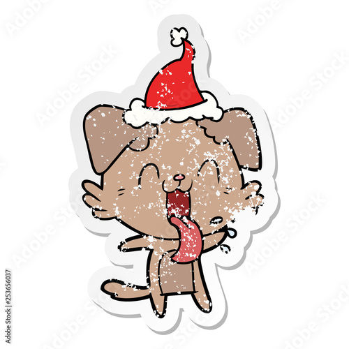 distressed sticker cartoon of a panting dog wearing santa hat