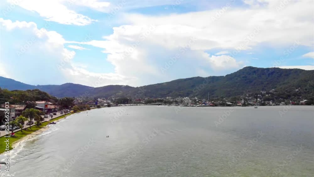 Aerial view of calm lake with mountains in back on the island of Florianopolis in Brazil - forward dolly Aerial view of calm lake with mountains in back on the island of Florianopolis in Brazil - forward dolly