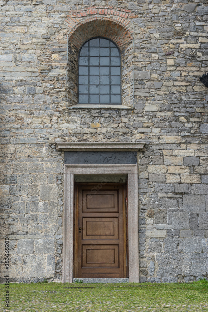 Fototapeta premium Italy, Varenna, Lake Como, a door is open in front of a brick building