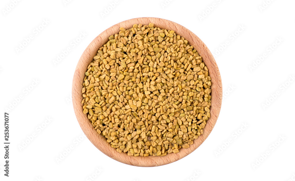 fenugreek seeds in wooden bowl isolated on white background. Spices and food ingredients. fenugreek seeds in wooden bowl isolated on white background. Spices and food ingredients.