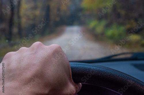 Vászonkép Hand driving car down gravel road.