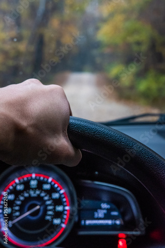 Hand driving down gravel road.