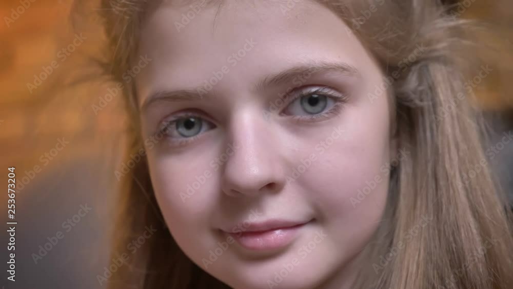 Close-up portrait of small pretty caucasian girl watching calmly into camera in cosy home atmosphere. Close-up portrait of small pretty caucasian girl watching calmly into camera in cosy home atmosphere.
