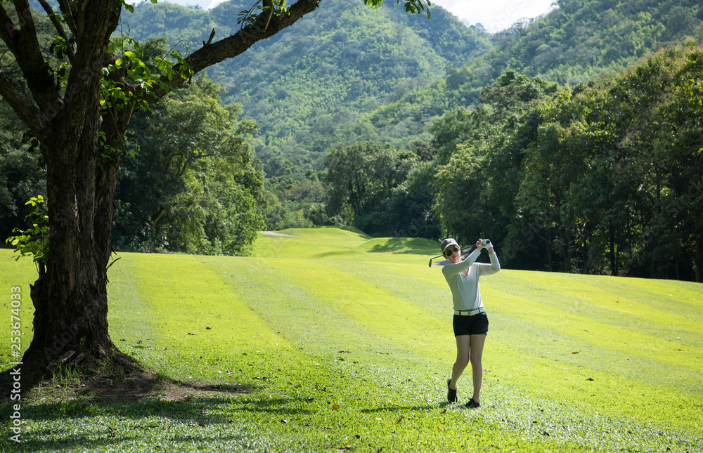 Asian woman playing golf on a beautiful natural golf course Asian woman playing golf on a beautiful natural golf course