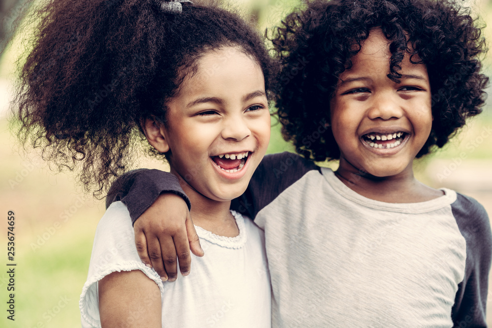 Happy little boy and girl in the park. Two African American children ...